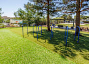 Thumbnail 46 of 142 - A park with a grassy area and exercise equipment.