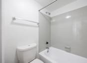 Thumbnail 121 of 142 - A white toilet and bathtub in a bathroom.