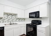 Thumbnail 123 of 142 - A black microwave oven is on top of a black stove.