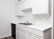 Thumbnail 135 of 142 - A kitchen with white cabinets and a black dishwasher.