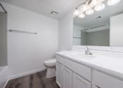 Thumbnail 92 of 142 - A white bathroom with a toilet, sink, and mirror.