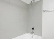 Thumbnail 93 of 142 - A white tiled shower with a shower head and a drain.