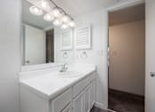 Thumbnail 98 of 142 - A white bathroom with a sink and mirror.