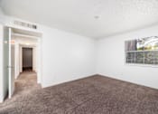 Thumbnail 99 of 142 - A room with a carpeted floor and a window with blinds.