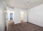 Thumbnail 103 of 142 - A room with white walls and carpeted floor with two doors.
