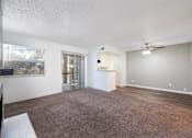 Thumbnail 107 of 142 - A spacious room with a carpeted floor and a ceiling fan.