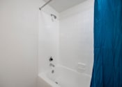 Thumbnail 79 of 142 - A white bathtub with a shower head and faucet.