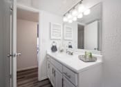 Thumbnail 80 of 142 - A bathroom with a white counter and a mirror above it.