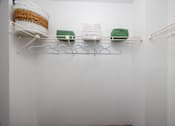 Thumbnail 87 of 142 - A white shelf with three hangers and two green objects.
