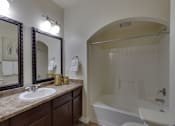 Thumbnail 39 of 39 - A bathroom with a sink, mirror, toilet and bathtub.