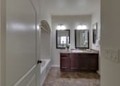 Thumbnail 37 of 39 - A bathroom with a vanity and a mirror.