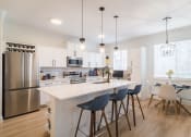 Thumbnail 22 of 39 - a kitchen with a large island and a dining table with chairs at Terracina, Colorado