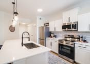 Thumbnail 23 of 39 - kitchen with white cabinets and stainless steel appliances at Terracina, Broomfield, CO 80020