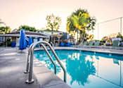 Thumbnail 19 of 27 - A pool with a ladder in the foreground and people in the background at Nola 624 Apartments, California, 91790