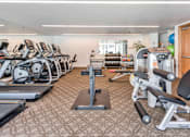 Thumbnail 101 of 104 - A gym with treadmills, exercise bikes, and weight machines at The Grand Apartments, Oakland 94612