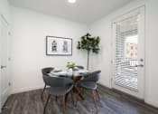 Thumbnail 43 of 87 - A dining room with a table set for two and a potted plant on the side.