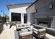 Thumbnail 21 of 87 - A patio with a fireplace and chairs.
