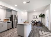 Thumbnail 40 of 87 - A modern kitchen with a dining table and chairs.