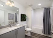 Thumbnail 47 of 87 - A bathroom with a toilet, sink, and shower.