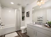 Thumbnail 48 of 87 - A white bathroom with a toilet, sink, and shower.