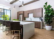 Thumbnail 13 of 85 - A modern kitchen with a white countertop and brown cabinets.