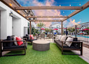 Thumbnail 26 of 85 - A patio with a black couch and a wooden table.