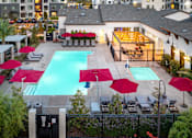 Thumbnail 22 of 85 - A pool surrounded by red umbrellas and chairs.