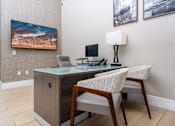 Thumbnail 8 of 85 - leasing office with a desk and a chair with a lamp on it.