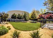Thumbnail 33 of 85 - A large white dome-like structure is surrounded by a fence and greenery.