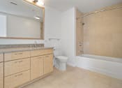 Thumbnail 71 of 104 - A bathroom with a toilet, sink, and bathtub at The Grand Apartments, Oakland, CA, 94612