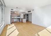Thumbnail 53 of 104 - A kitchen with wooden floors and white walls at The Grand Apartments, Oakland, California