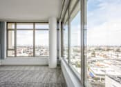 Thumbnail 75 of 104 - A room with a large window overlooking a cityscape at The Grand Apartments, Oakland