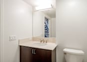 Thumbnail 89 of 104 - A bathroom with a sink, toilet and mirror at The Grand Apartments, Oakland