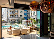 Thumbnail 117 of 137 - This is a modern living room with a view of a pool and apartment buildings.