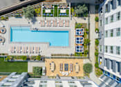 Thumbnail 111 of 137 - A large swimming pool surrounded by lounge chairs and umbrellas.