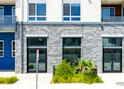 Thumbnail 134 of 137 - A modern building with a blue door and a red and white sign on the left.