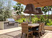 Thumbnail 112 of 137 - A patio with a table and chairs and a grill.