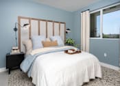 Thumbnail 26 of 137 - A bedroom with a bed, nightstand, and window.