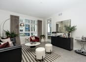 Thumbnail 8 of 137 - A modern living room with a black sofa, a red chair, and a black and white striped rug.