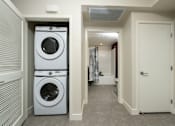 Thumbnail 22 of 137 - A laundry room with a washer and dryer stacked on top of each other.