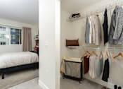 Thumbnail 20 of 137 - A bedroom with a bed, a window, and a closet with clothes.