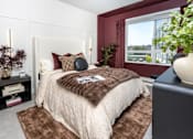 Thumbnail 4 of 137 - A bedroom with a large bed and a window overlooking a cityscape.