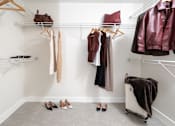 Thumbnail 14 of 137 - A white closet with clothes and shoes.