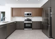 Thumbnail 34 of 137 - A modern kitchen with a stainless steel refrigerator on the right.