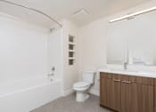 Thumbnail 41 of 137 - A white bathroom with a toilet, sink, and bathtub.