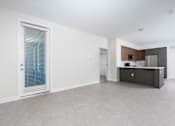 Thumbnail 39 of 137 - A spacious, empty room with a window, a counter, and a door.