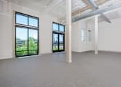 Thumbnail 36 of 137 - A large empty room with a view of the outside through the windows.