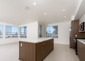 Thumbnail 46 of 137 - A modern kitchen with a large island and a view of the city.