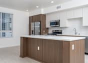 Thumbnail 50 of 137 - A modern kitchen with a white countertop and wooden cabinets.