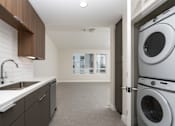 Thumbnail 71 of 137 - A modern laundry room with a washer and dryer.